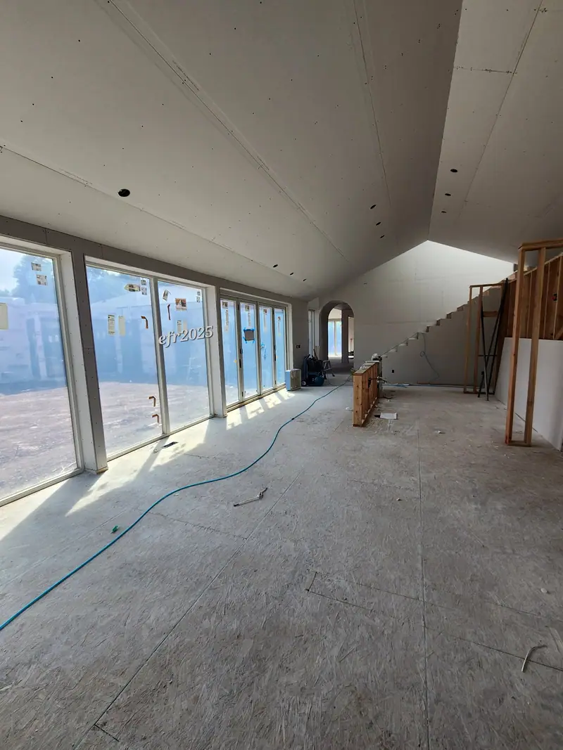 Barndominium great room drywalled with tall windows along one wall
