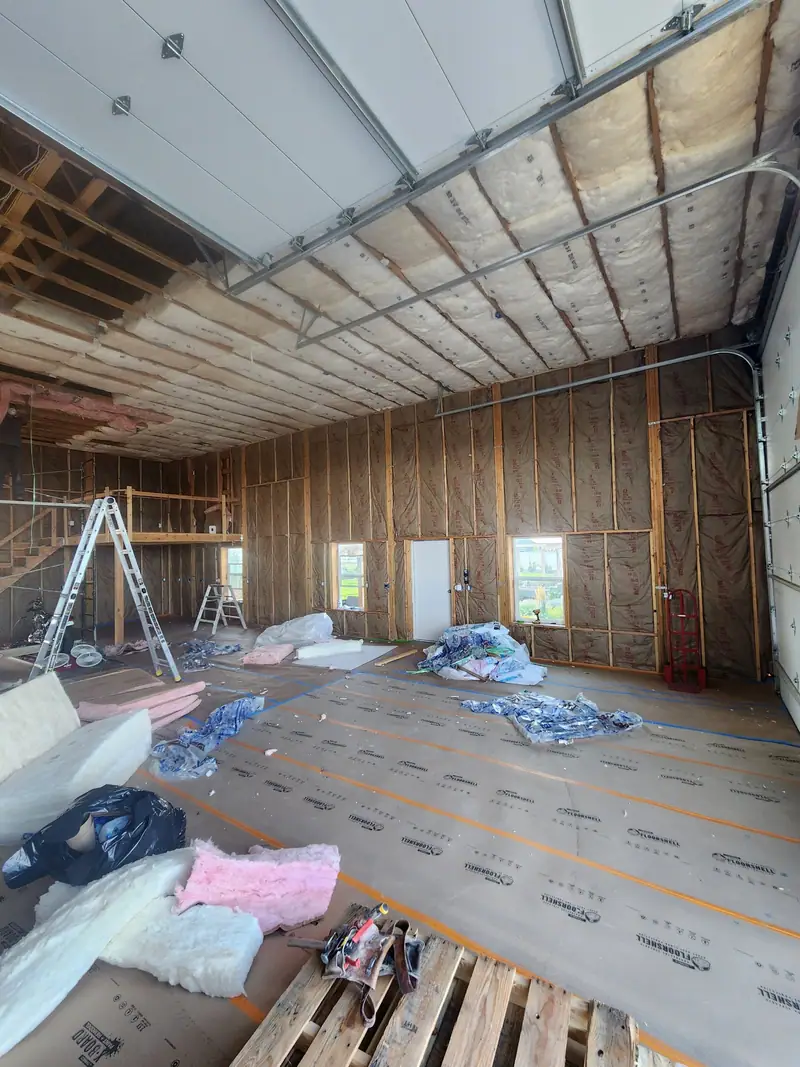 Barndominium interior framed and insulated under steel roof trusses