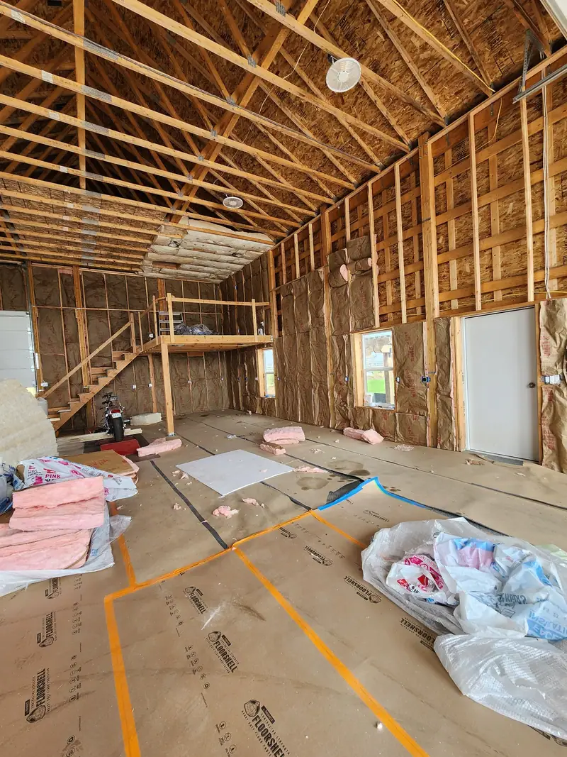 Barndominium framing with a loft and stair under open trusses