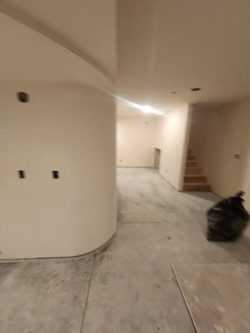 Curved drywall wall finished smooth in a basement