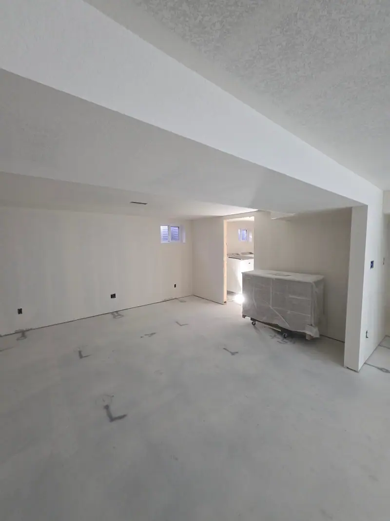 Basement hung and finished in drywall, ready for paint, with small windows