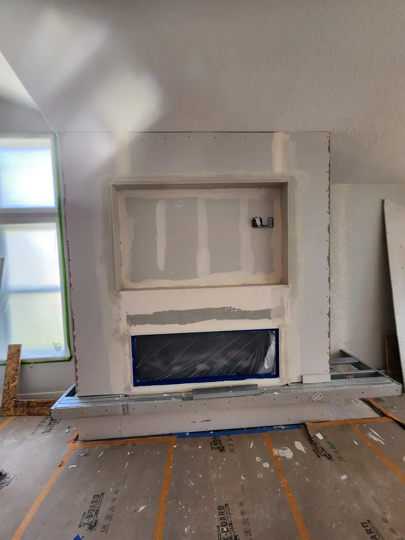 Fireplace wall in drywall with a linear fireplace and TV niche before finish