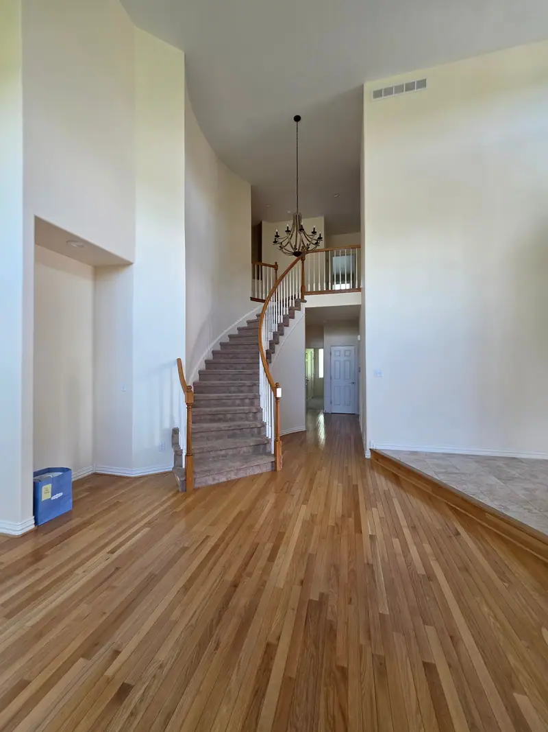Two-story foyer with a curved staircase and hardwood floors