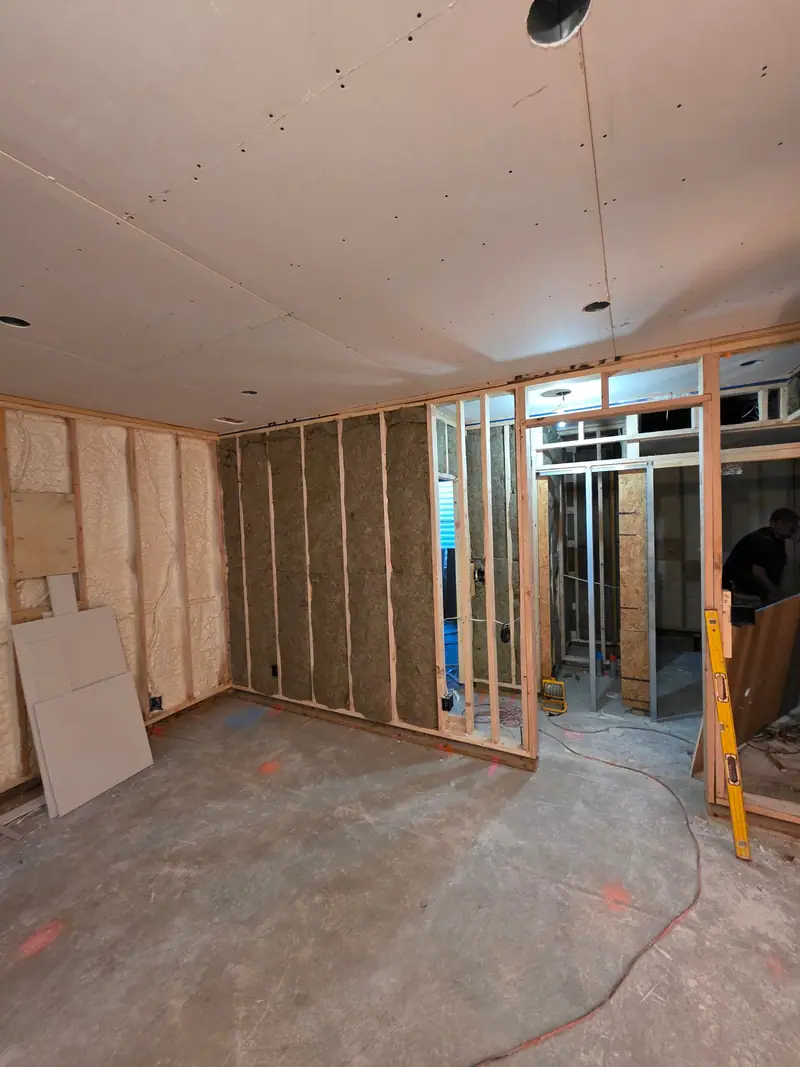 Room framed with new stud walls and insulation before drywall