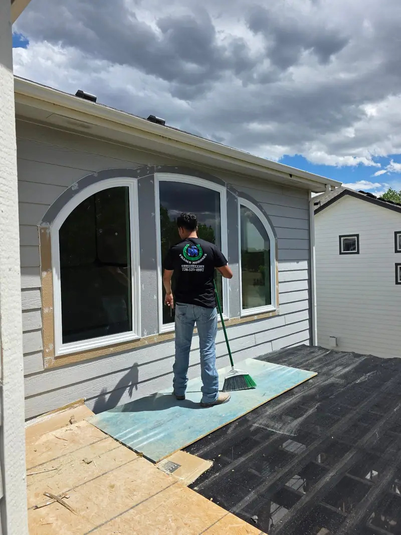 Franco Morones Construction crew member at a newly installed arched window on a grey-sided house