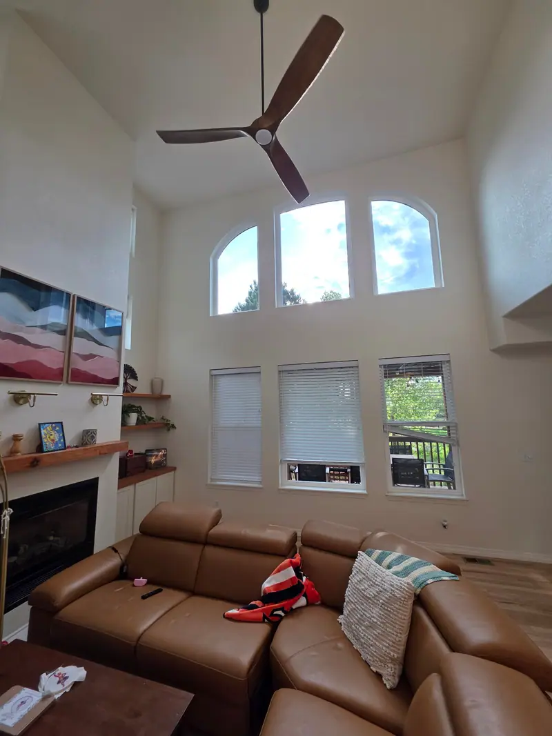 Finished two-story great room with arched windows, fireplace and floating wood shelves