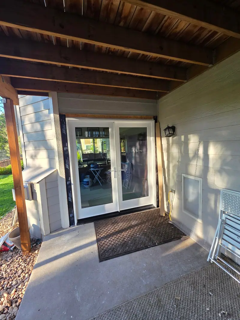 New white French doors and siding trim under a deck