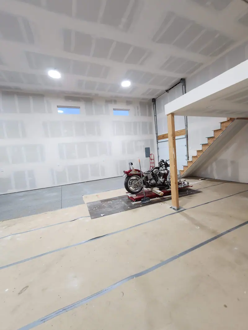 Large garage shop drywalled and taped with recessed lights and a loft with stairs