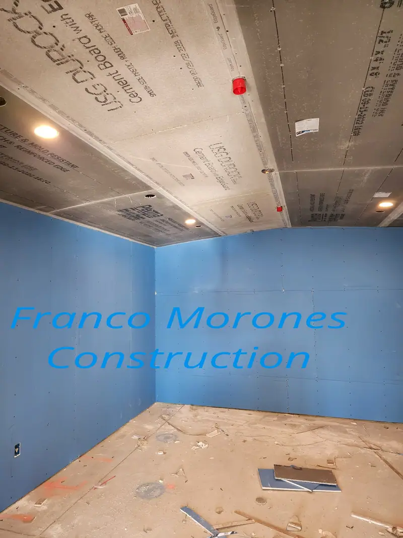 Bathroom walls coated in blue waterproofing with a cement board ceiling, ready for tile