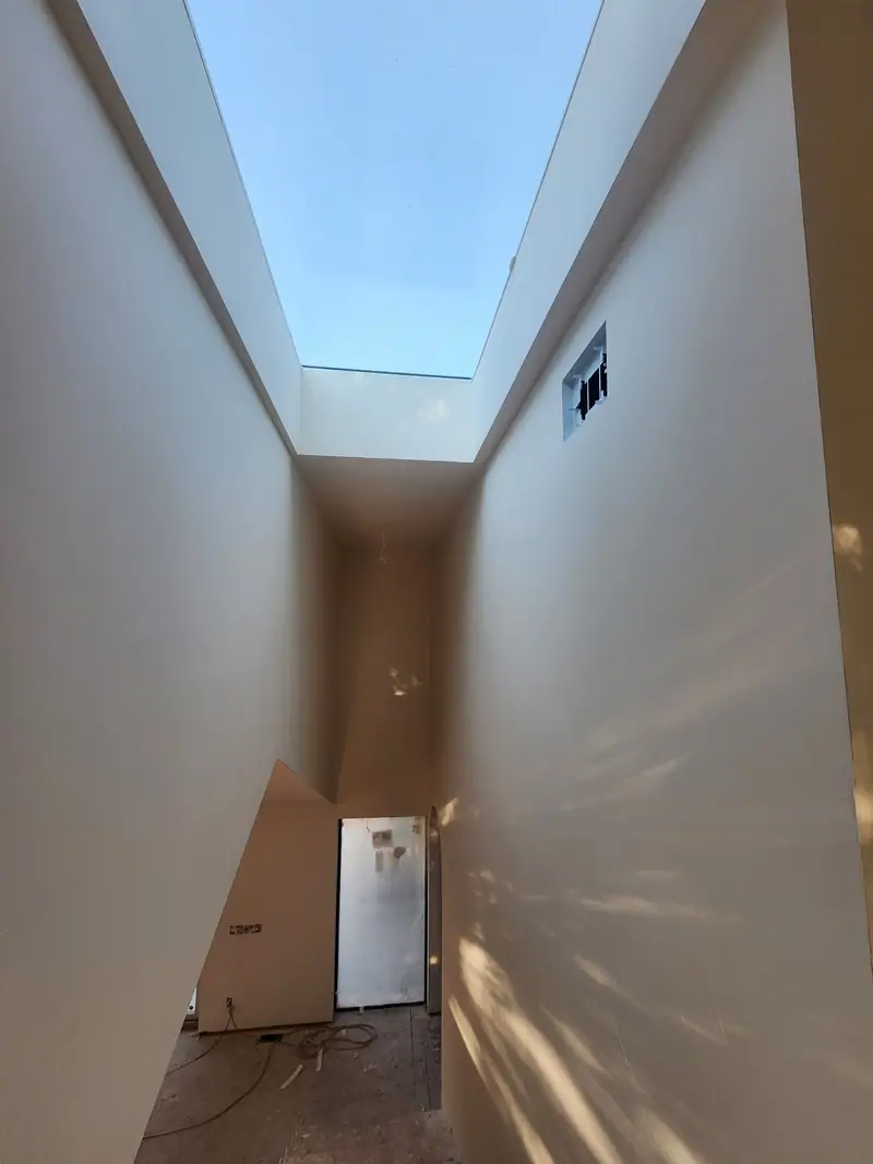 Tall drywalled skylight shaft over a hallway